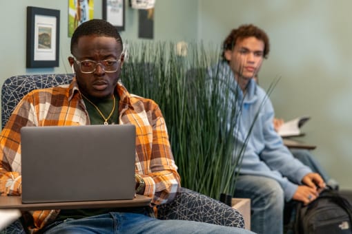 two persons siting, looking at a laptop at Proximity at ODU in Norfolk, Virginia 23508