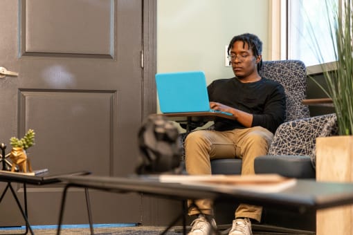 a man sitting in a chair with a laptop on his lap at Proximity at ODU in Virginia 23508