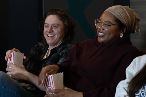 two women sitting on a couch laughing and eating popcorn at Proximity at ODU in Norfolk, Virginia 23508
