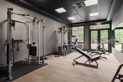 a gym with weights and equipment in a room with windows
