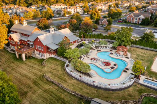 an aerial view of a swimming pool in front of a house