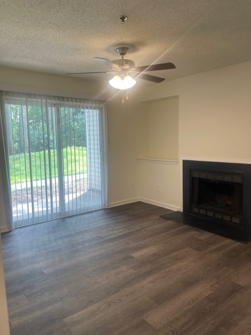 a living room with a fireplace and a ceiling fan