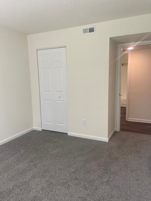 an empty living room with white walls and a door