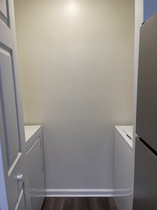 an empty laundry room with two washes and a dryer