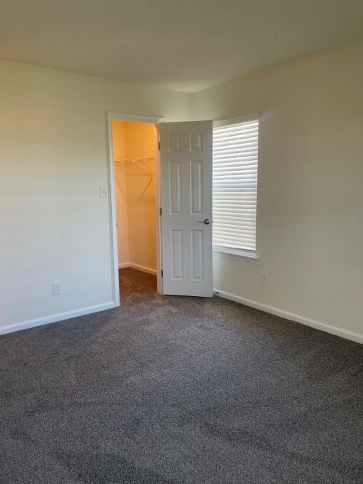 an empty living room with a door to a closet