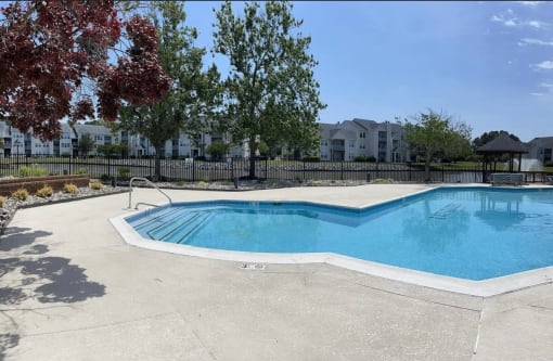a swimming pool and a resort style pool with trees and buildings in the background