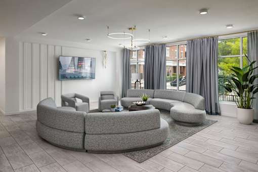 A modern living room with a grey sofa set and a television on the wall.