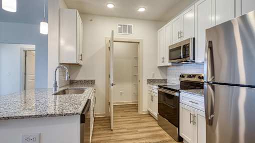 A kitchen with a stainless steel refrigerator, microwave, and oven.