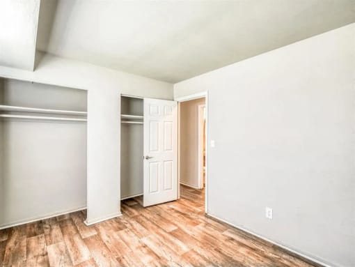 an empty room with white walls and wood floors at Gates of West Bay, Virginia, 23503
