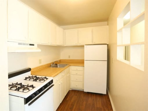 a kitchen with white appliances and white cabinets at Gates of West Bay, Norfolk