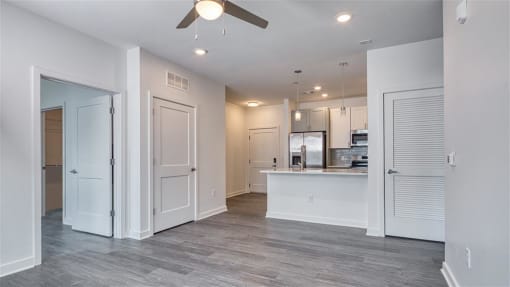 an empty living room and kitchen with a ceiling fan at The Port at East Beach Apartments and Marina, Norkfolk, 23518
