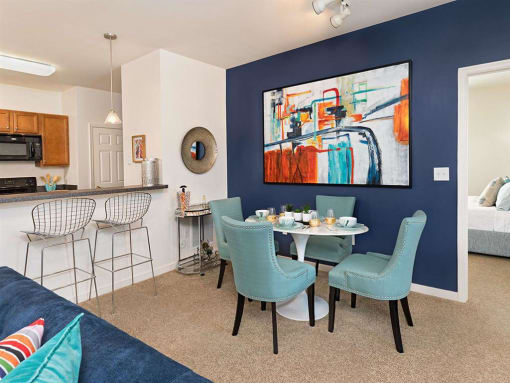 a dining area with a table and chairs and a kitchen in the background at Addison Crater Woods, Virginia