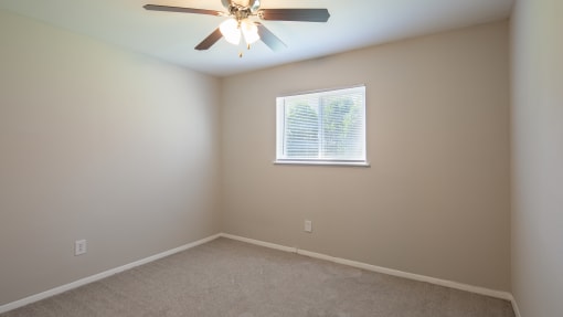 a bedroom with a ceiling fan and a window