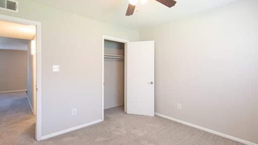 a bedroom with a ceiling fan and closet