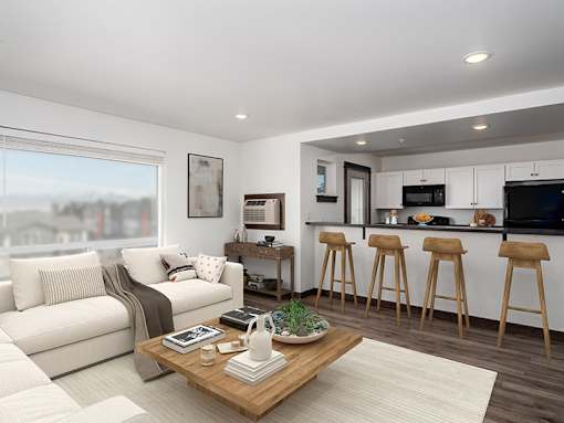 A modern living room with a white sofa, a wooden coffee table, and a kitchen area in the background.
