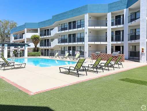 A large building with a pool in front of it.