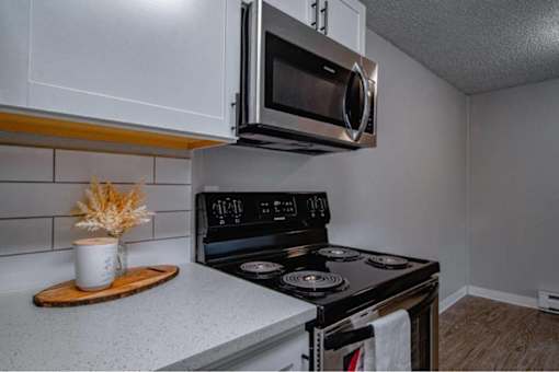 A modern kitchen with a stove, oven, and microwave.