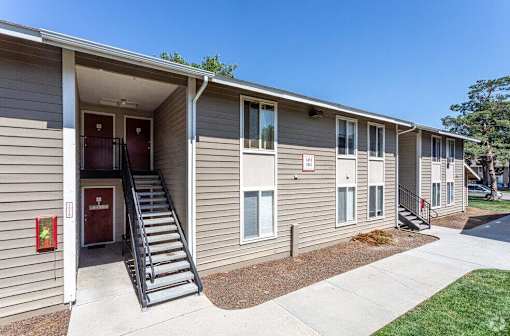 A building with a red door and a staircase leading to the entrance.