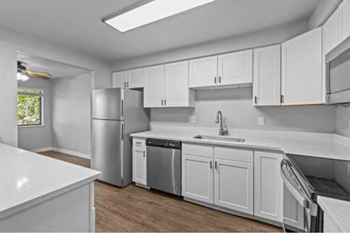 A kitchen with white cabinets and appliances.