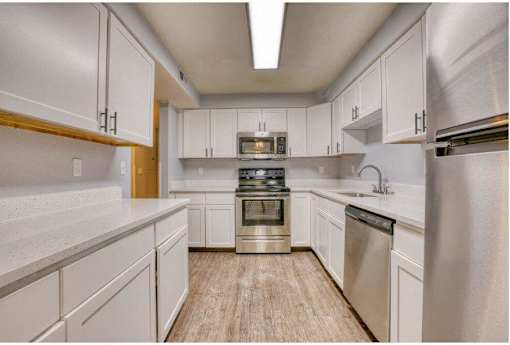 A kitchen with white cabinets and stainless steel appliances.