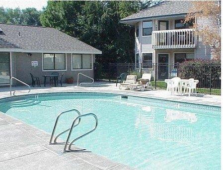 A small pool with a diving board in front of a house.
