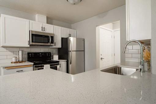 A kitchen with white cabinets and a granite countertop.