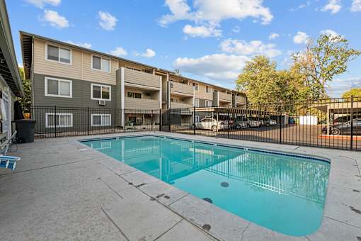 A small pool in a courtyard surrounded by a fence.