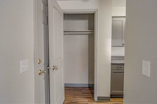 A white door with a gold handle is open to a kitchen.