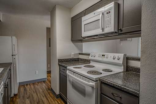 A kitchen with a stove, oven, and microwave.
