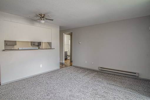 A room with a ceiling fan and a wall-mounted shelf.