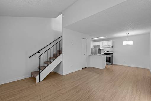 A kitchen with a staircase leading to the upper floor.