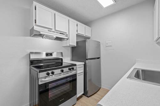 A modern kitchen with a stove, oven, and refrigerator.