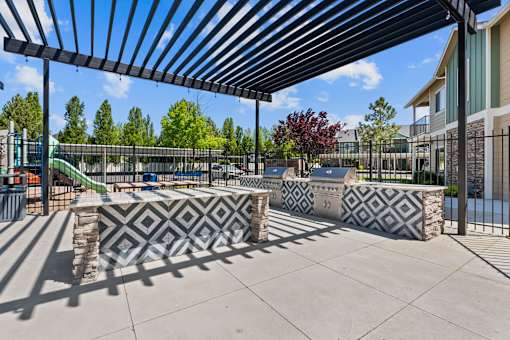 A playground with a black and white patterned bench under a black and white striped awning.