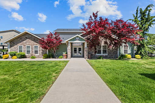 A building with a stone facade and a green lawn in front.