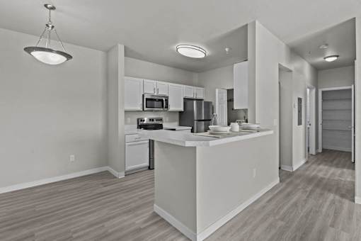 A modern kitchen with a white island and stainless steel appliances.