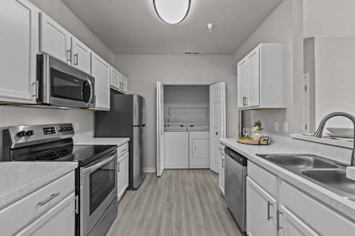 A modern kitchen with white cabinets and stainless steel appliances.