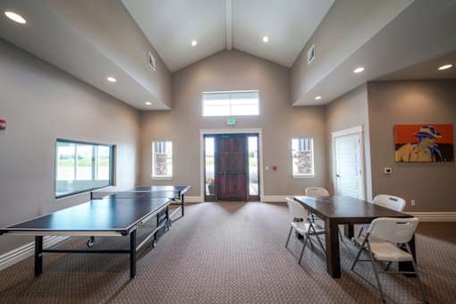 A room with a long table and chairs and a painting on the wall.
