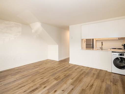 A kitchen with a washing machine in the corner.