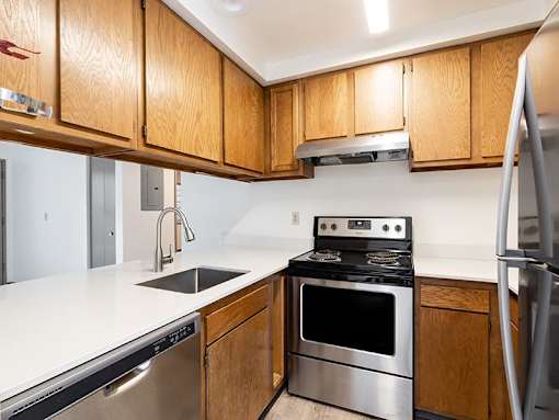 A kitchen with wooden cabinets and stainless steel appliances.