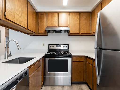 A modern kitchen with wooden cabinets and stainless steel appliances.