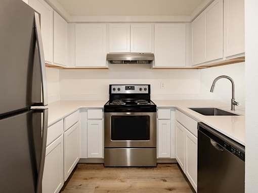 A modern kitchen with a stainless steel refrigerator and oven.