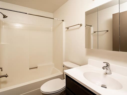 A white toilet sits next to a white sink in a bathroom.