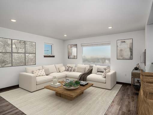 A living room with a white couch, a coffee table, and a painting on the wall.