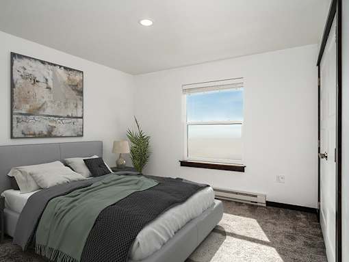 A bedroom with a large bed and a window overlooking the beach.