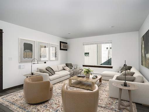 A living room with a white couch and a rug.