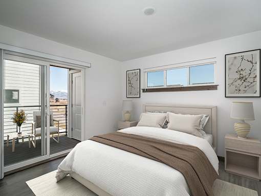 A bedroom with a large bed and a view of the outdoors through a sliding glass door.