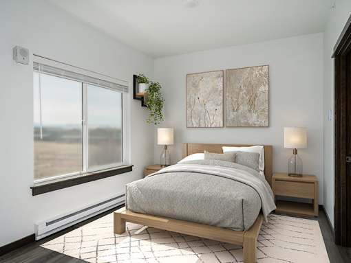 A bedroom with a large bed and two lamps.