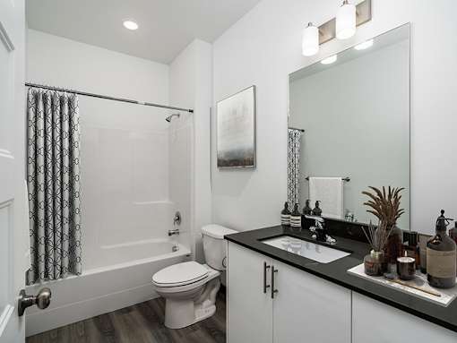 A bathroom with a toilet, sink, and shower.