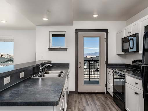 A modern kitchen with a sink, stove, and oven.
