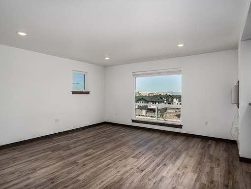 Empty room with wooden flooring and a window.